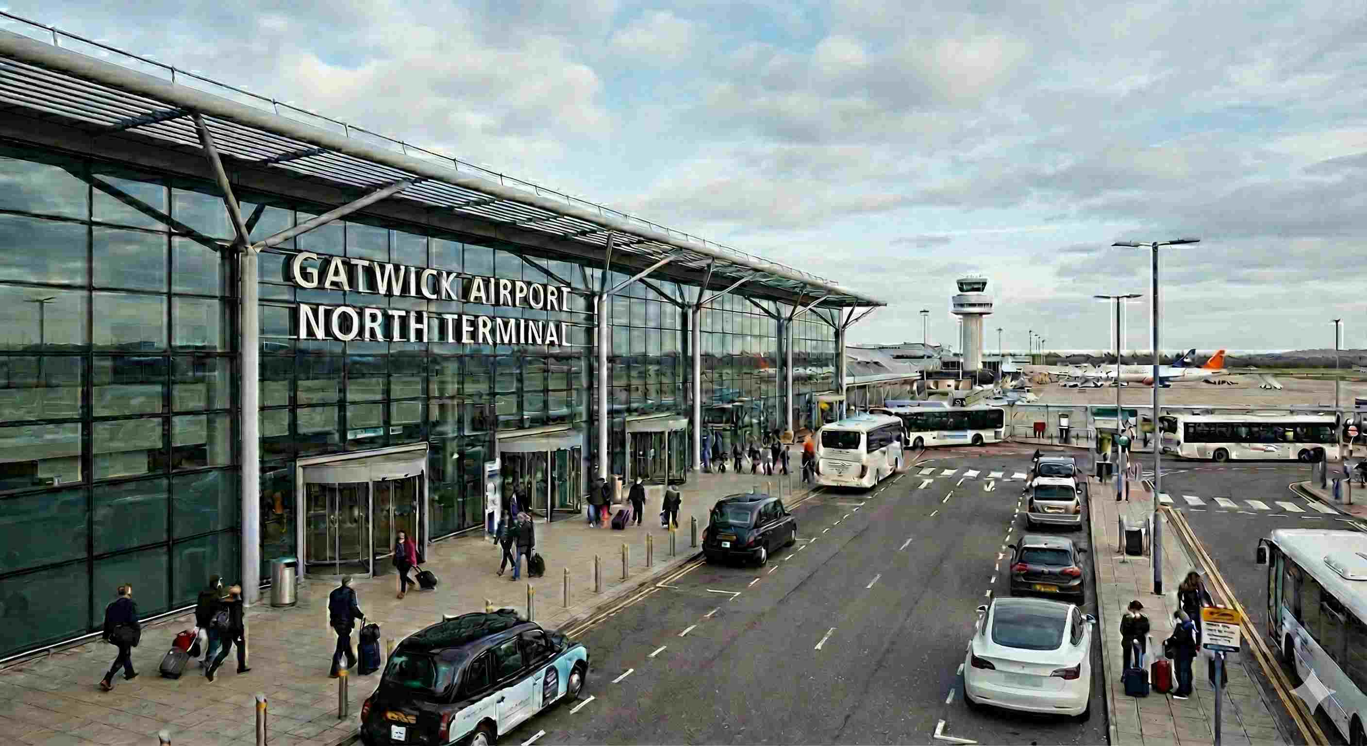 White Tesla Model 3 electric taxi at Gatwick Airport terminal - Professional airport transfer service from North Wales
